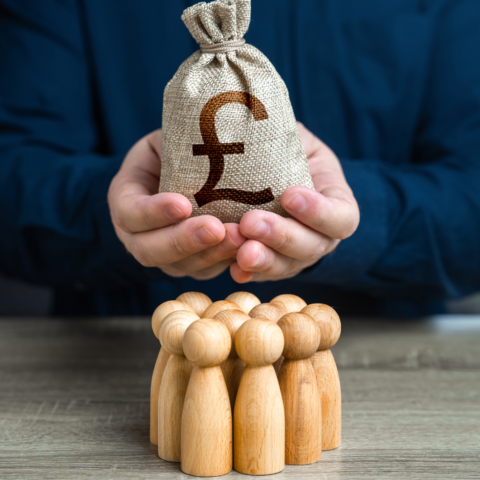90476590 a man is holding a british pound sterling money bag over a group of people figurines political lobbying payment for labor and services generation of funds organization of
